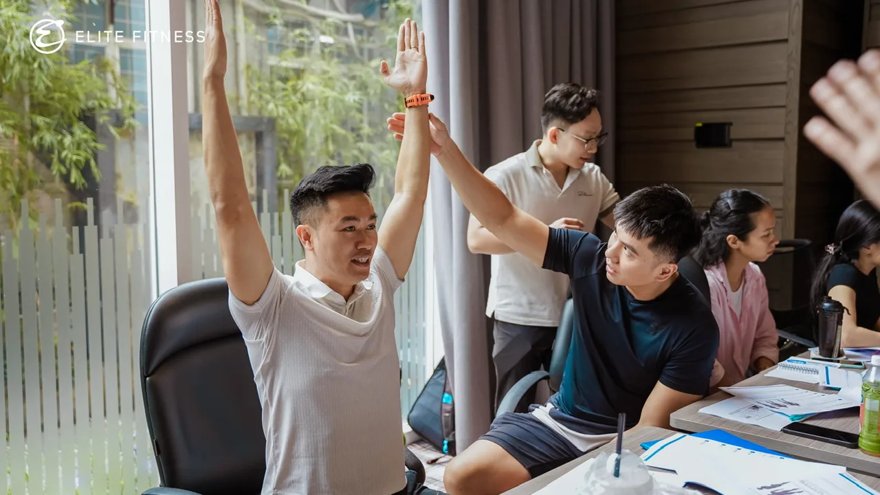 Huấn luyện viên Elite Fitness làm việc theo nhóm, ghi chép và trao đổi trong chương trình đào tạo Road2Rehab tại Hà Nội